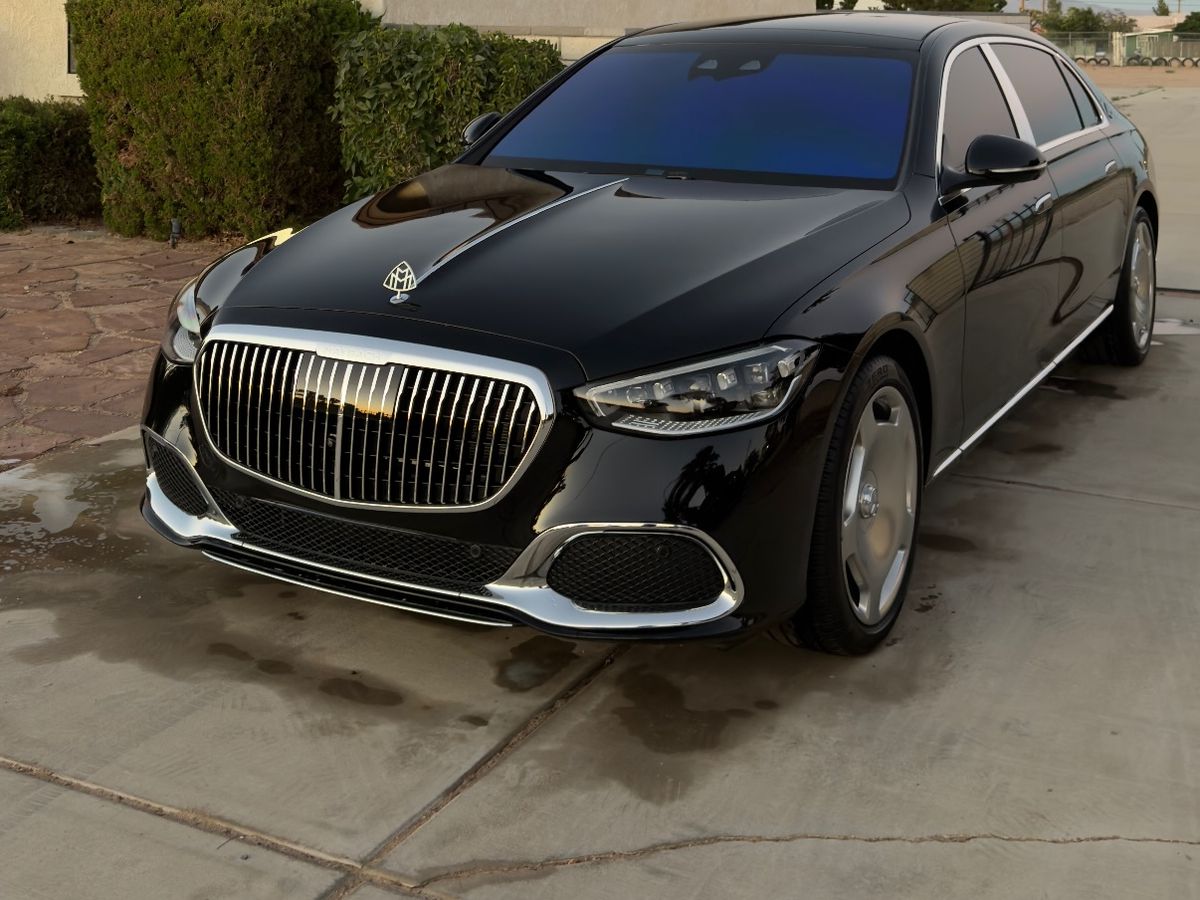 A black Mercedes-Maybach S-Class in a client driveway at dusk