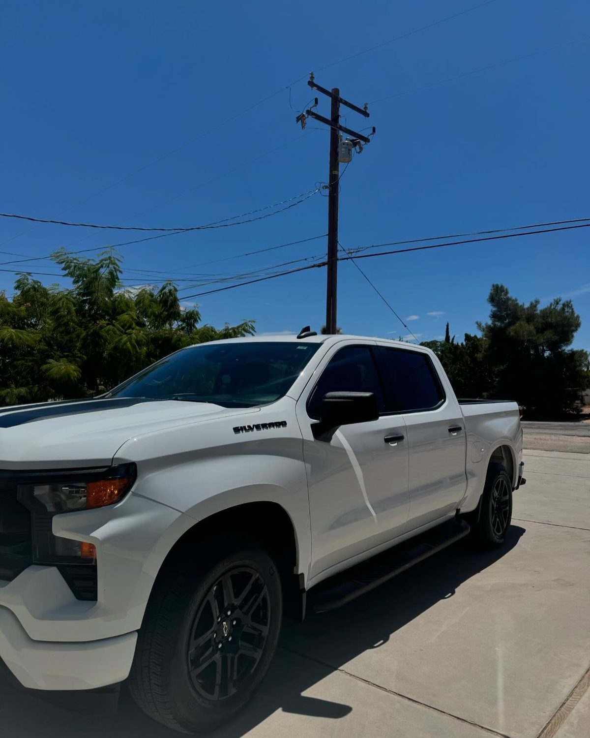 A white Chevrolet Silverado in a client driveway in the High Desert