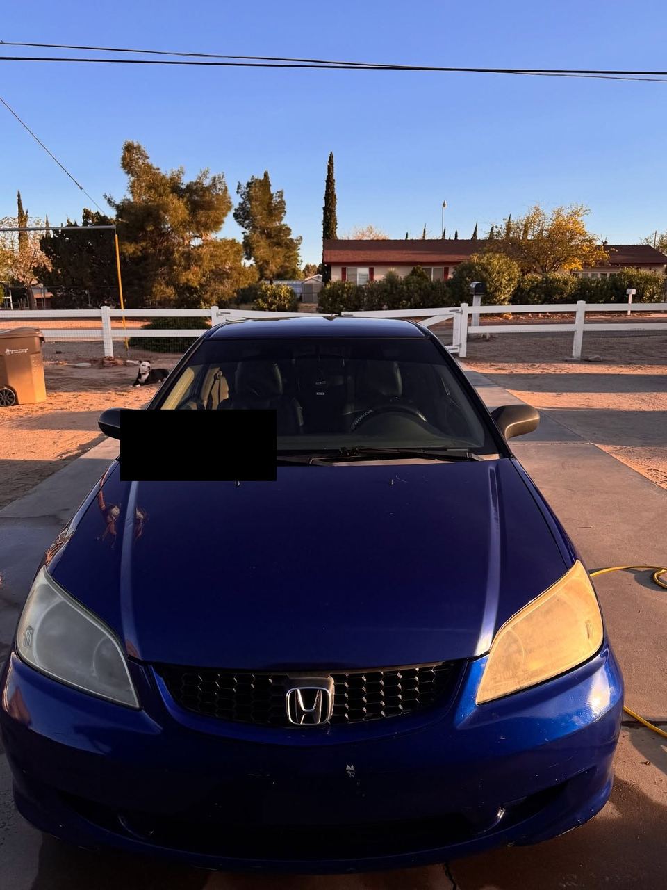 Blue Honda Civic parked in a driveway, front on