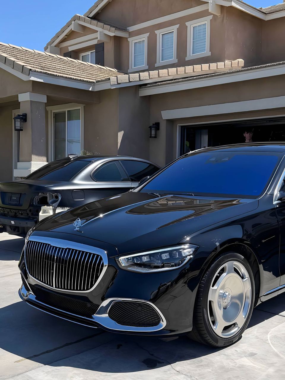 Black Mercedes-Maybach S-Class parked in a driveway, front three-quarter view