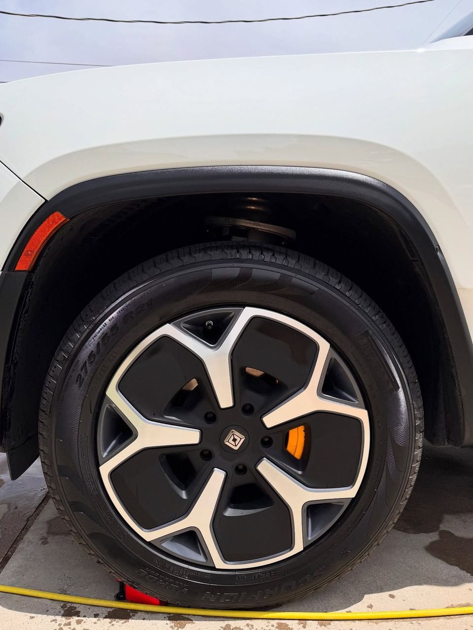 Rivian R1S wheel and orange brake caliper after cleaning
