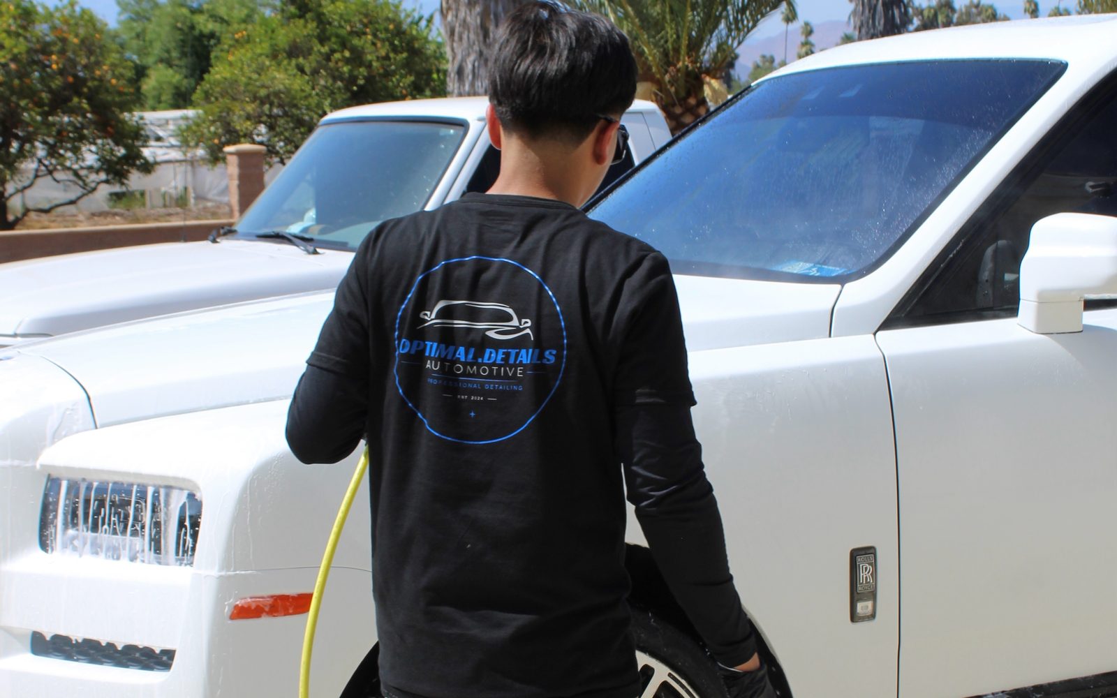 A technician foam washing an SUV during a mobile detail
