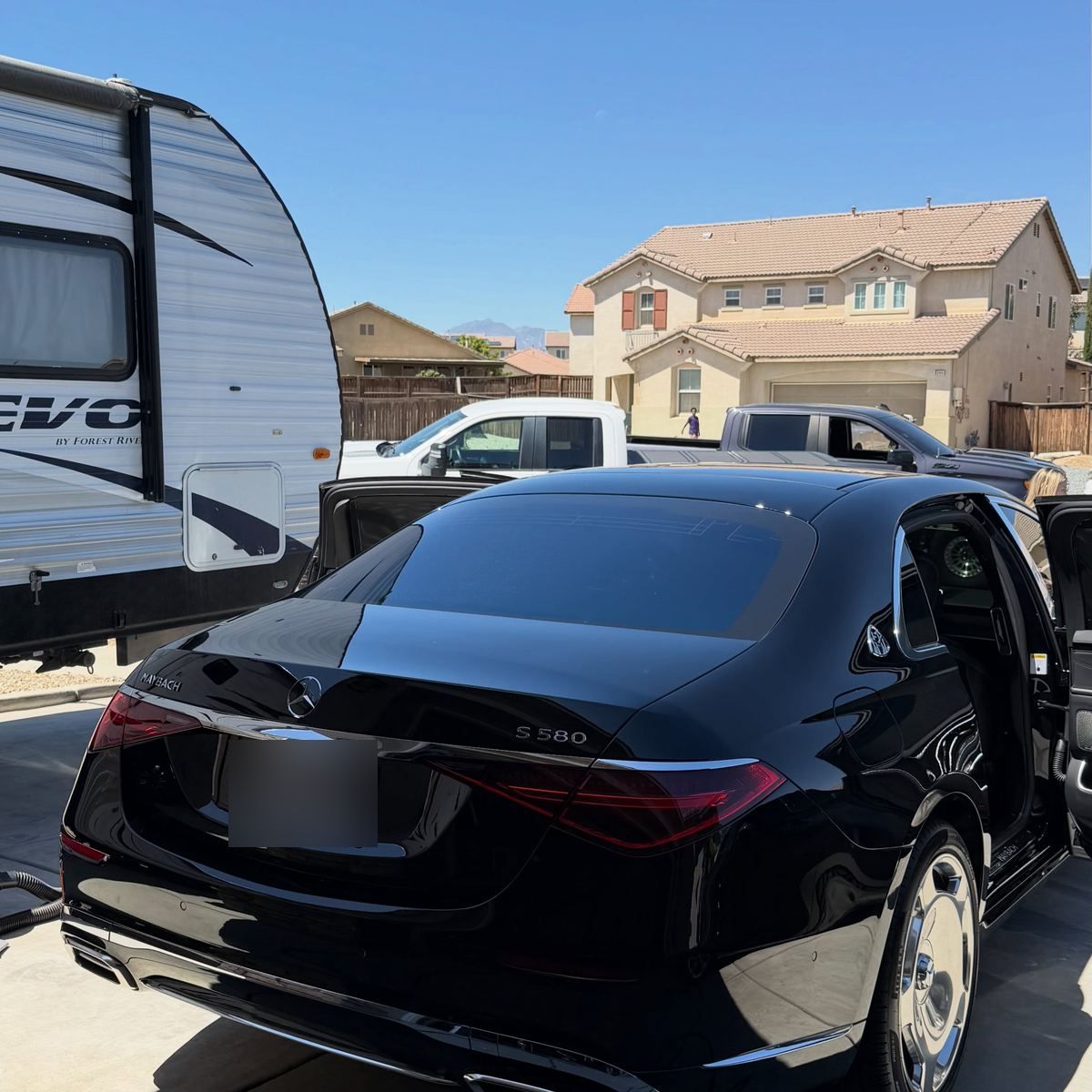 The rear of a black Mercedes-Maybach S-Class in a driveway