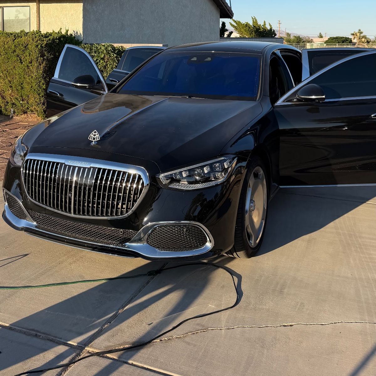 A black Mercedes-Maybach S-Class front on, in fading light