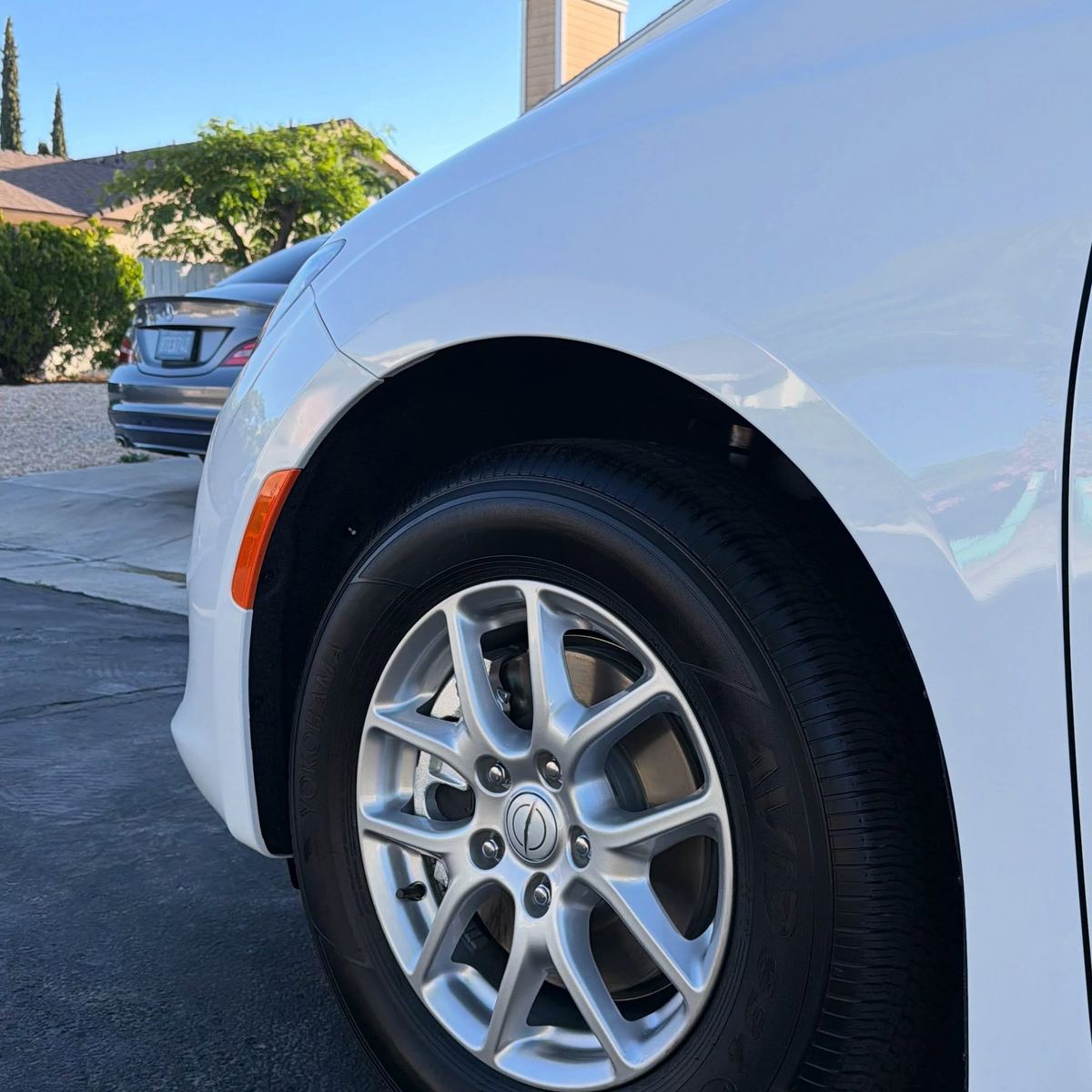 The front wheel and fender of a white Mercedes-Benz CLA after decontamination