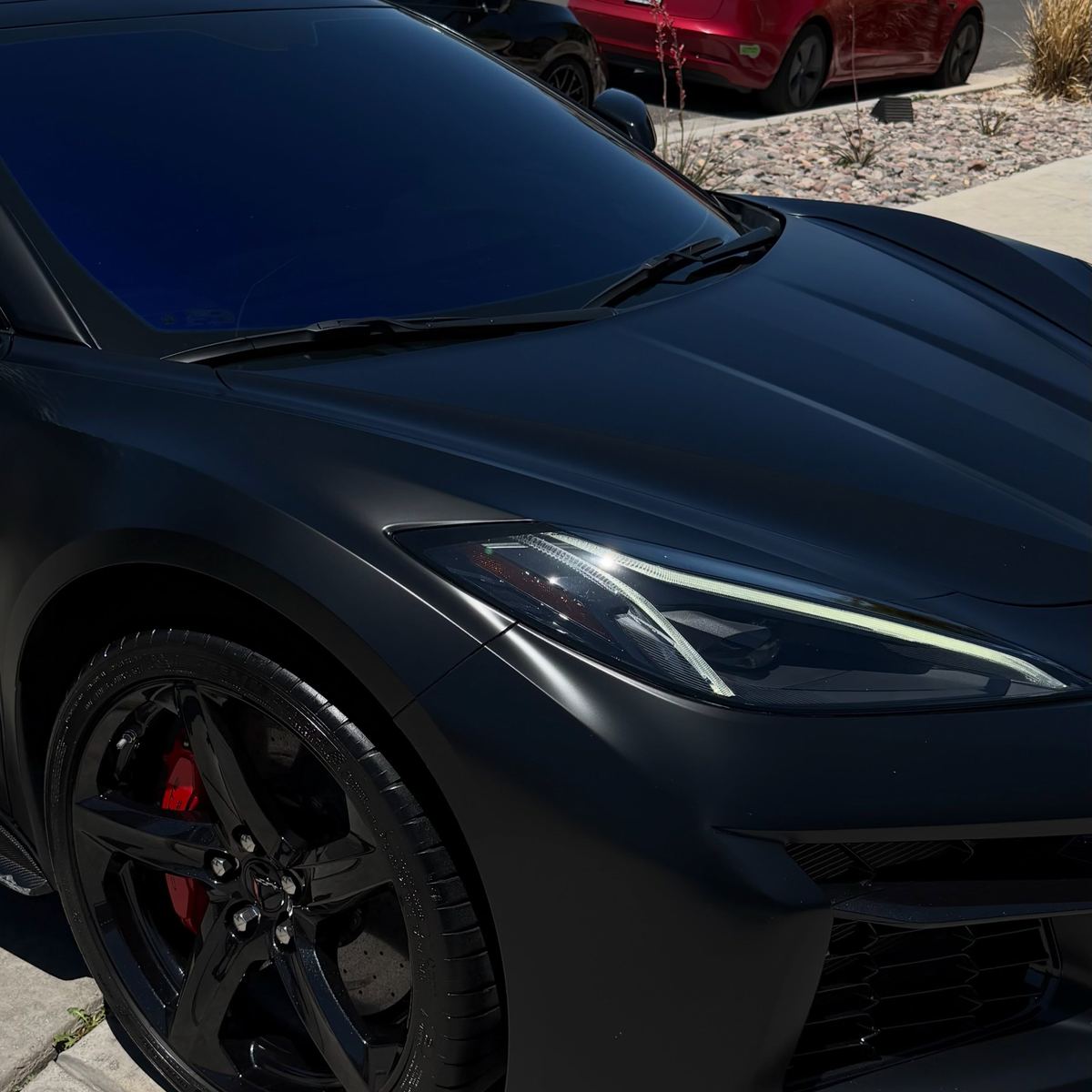 The nose of a black Chevrolet Corvette holding a deep gloss