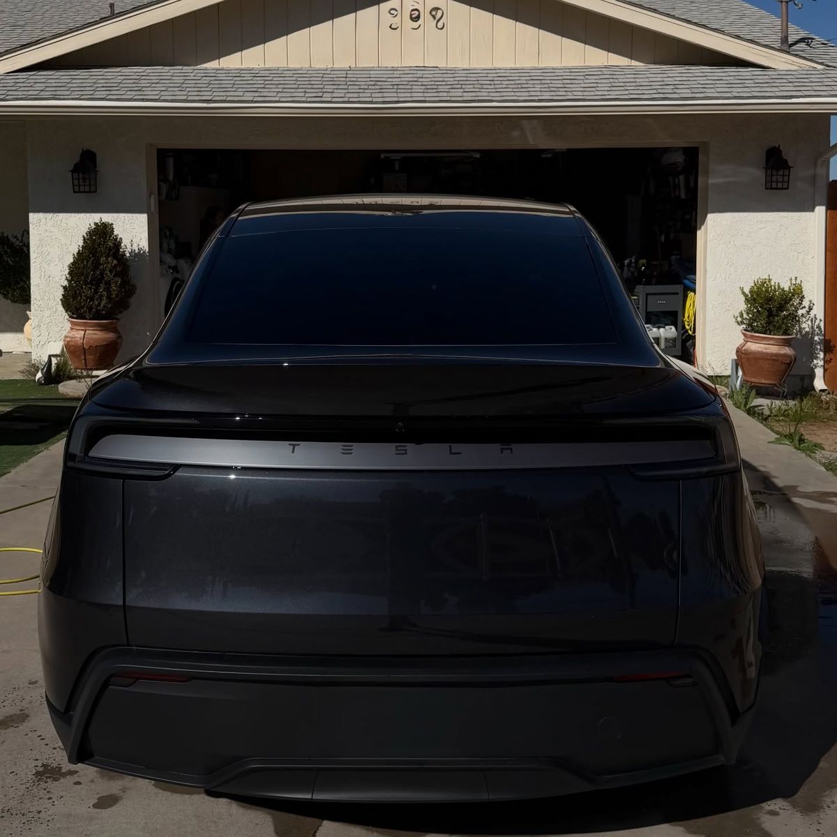 The rear of a black Tesla, panels finished dark and clean